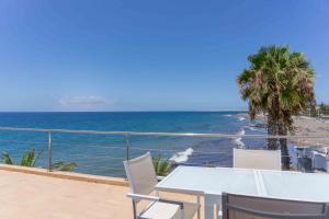 una mesa y sillas en un balcón con vistas al océano en Bungalow Vacacional Nueva Suecia 716, en San Agustín