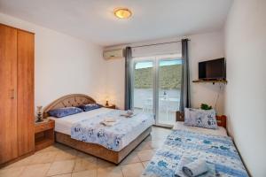 a bedroom with two beds and a balcony at Apartments Vesna in Tivat