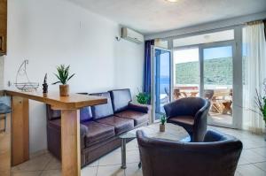 a living room with a couch and a table and chairs at Apartments Vesna in Tivat