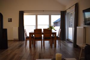 a dining room with a table and chairs and a large window at Haus MeerErleben - Urlaub mit Hund an der Nordsee in Schweiburg