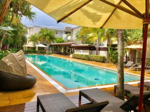a large swimming pool with chairs and an umbrella at Salt Beach Luxury Apartments by Kingscliff Accommodation in Kingscliff