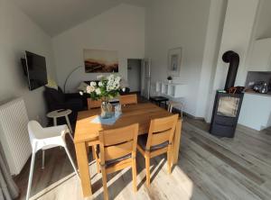 a living room with a wooden table and chairs at Haus MeerErleben - Urlaub mit Hund an der Nordsee in Schweiburg