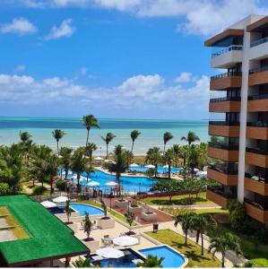 uma vista aérea do resort com o oceano ao fundo em Apartamento a beira mar com piscina estilo resort em Cabedelo