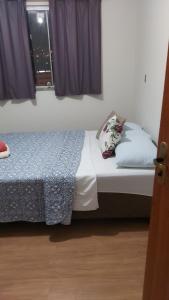 a bedroom with a bed and a window at Quarto 201 in Juiz de Fora