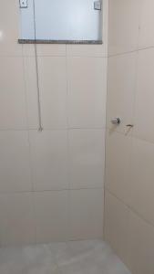 a bathroom with a shower with white tiles at Quarto 201 in Juiz de Fora +5 photos