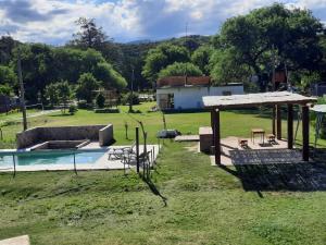 vistas a un patio con piscina y una casa en Cabañas Ismiango "Agua de los pajaritos" en Collagasta