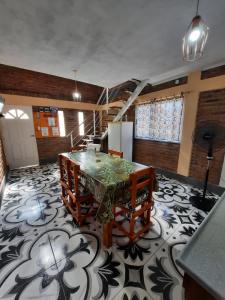 Habitación con mesa, sillas y suelo de baldosa. en Cabañas Ismiango "Agua de los pajaritos" en Collagasta
