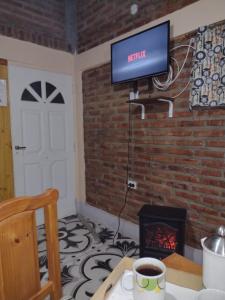 sala de estar con TV y chimenea en Cabañas Ismiango "Agua de los pajaritos" en Collagasta