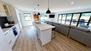 een keuken en een woonkamer met een bank en een tafel bij Solar on Snowmass Red Door in Ohakune