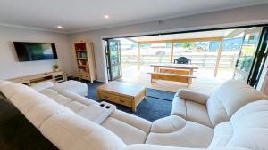 uma sala de estar com um sofá branco e uma mesa em Ohakune Solar on Snowmass em Ohakune