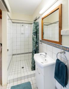 a bathroom with a shower, sink, and toilet at Lync Haven Rainforest Retreat in Diwan