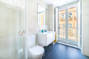 a white bathroom with a toilet and a window at Blue by the River 2 - elegant two-bedroom in Santos in Lisbon