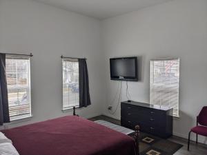 a bedroom with a bed and a tv on the wall at Cozy *Downtown Getaway* in San Antonio