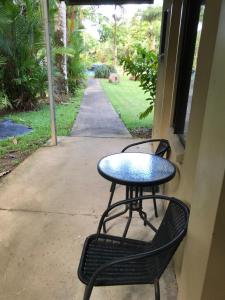 a patio table with chairs and a blue umbrella at Lync Haven Rainforest Retreat in Diwan