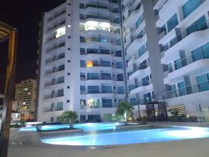 un grande condominio con piscina di notte di Hermoso y cómodo apartamento Rodadero Sur (Santa Marta) a Santa Marta