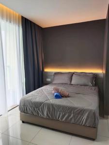 ein Schlafzimmer mit einem Bett mit einem blau ausgestopften Tier darauf in der Unterkunft Urban360 Pool view stylist with android Tv in Batu Caves