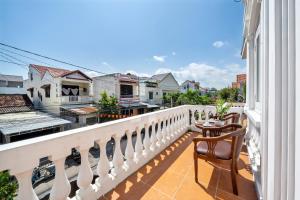 a balcony with a table and chairs looking out at the city at Gioan Boutique Villa in Hoi An