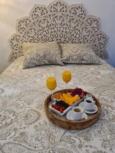 テール・ド・オーにあるTi Kaz Marigotのベッドの上にフルーツとドリンクのトレイを用意しています。