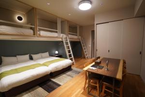 a bedroom with a bed and a desk and bunk beds at Riverside Hotel Sapporo in Sapporo