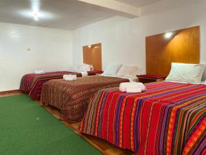 duas camas sentadas uma ao lado da outra num quarto em Hotel Wiñay Pacha Inn em Puno