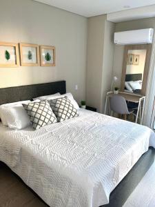 1 dormitorio con 1 cama blanca grande y escritorio en Confortable y exclusivo apartamento en Martinique Cielo Mar, en Cartagena de Indias