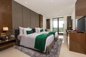 a hotel room with two beds and a flat screen tv at DIC Star Hotels & Resorts Vinh Phuc in Yen