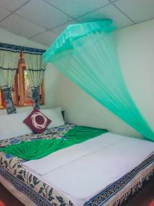 een bed in een kamer met een klamboe bij Green Grass Homestay in Sigiriya