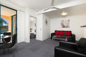 a living room with a black couch and red pillows at Aruba Surf Resort in Gold Coast