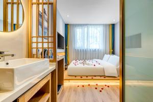 a bathroom with a bed and a sink and a tub at Happy Dragon Universal Vacation Hotel - close to Universal Studio and Wanda Plaza,free shuttle to the Resort,Free Coffee,Laundry in Beijing