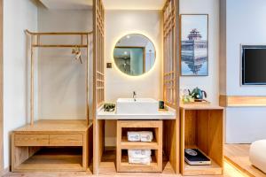 a bathroom with a sink and a mirror at Happy Dragon Universal Vacation Hotel - close to Universal Studio and Wanda Plaza,free shuttle to the Resort,Free Coffee,Laundry in Beijing