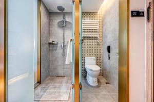 a bathroom with a toilet and a shower at Happy Dragon Universal Vacation Hotel - close to Universal Studio and Wanda Plaza,free shuttle to the Resort,Free Coffee,Laundry in Beijing