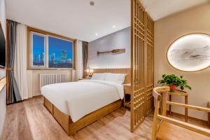 a hotel room with a bed and a mirror at Happy Dragon Universal Vacation Hotel - close to Universal Studio and Wanda Plaza,free shuttle to the Resort,Free Coffee,Laundry in Beijing