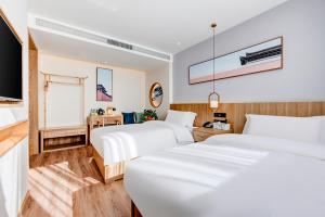 a hotel room with two beds and a television at Happy Dragon Universal Vacation Hotel - close to Universal Studio and Wanda Plaza,free shuttle to the Resort,Free Coffee,Laundry in Beijing