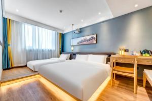 a hotel room with two beds and a desk at Happy Dragon Universal Vacation Hotel - close to Universal Studio and Wanda Plaza,free shuttle to the Resort,Free Coffee,Laundry in Beijing