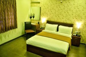 Postel nebo postele na pokoji v ubytování Hotel Arunachala