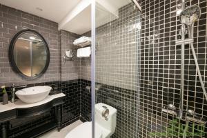 a bathroom with a sink and a toilet and a mirror at Hanoi Paradise Center Hotel & Spa in Hanoi