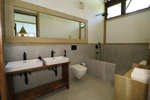 un bagno con due lavandini, un water e uno specchio di Satya Boutique Resort & Spa a Isola di Havelock