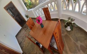una mesa de madera con un jarrón de flores. en Luxury cosy villa welcoming you by the beach en Malindi