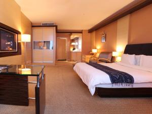 ミリにあるインペリアル ホテル ミリの大きなベッドとテレビがあるホテルの部屋