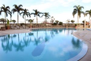 una gran piscina con palmeras en el fondo en Imperial Hotel Miri, en Miri