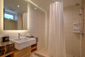 un bagno con lavandino e tenda da doccia di Mambruk Hotel & Convention a Serang