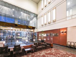 a lobby with couches and tables in a building at Utsunomiya Tobu Hotel Grande in Utsunomiya