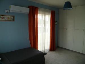 Schlafzimmer mit einem Bett und einem Fenster mit Vorhängen in der Unterkunft Room in Guest room - Datacom House - The Sky Blue Room in Nikosia