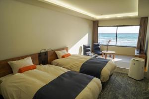 two beds in a room with a view of the ocean at Sinori205 in Hakodate