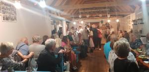 Une foule de personnes assises à des tables dans une pièce dans l'établissement Pensiunea Ramona, à Viscri