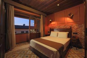 a bedroom with a bed and a brick wall at Sam Franss Boutique Otel in Hatay