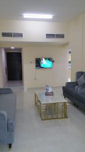 Al Rawda Apartments -Ajman في عجمان: غرفة معيشة مع أريكة وطاولة قهوة