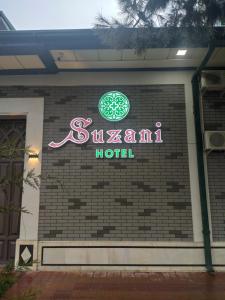 una señal para un hotel al lado de un edificio en Hotel Suzani Samarkand, en Samarkand