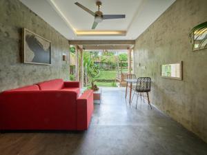 a living room with a red couch and a table at The Tempekan Heritage in Uluwatu