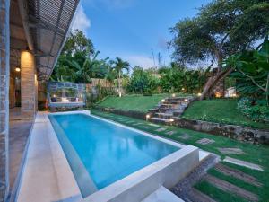 a swimming pool in the backyard of a house at The Tempekan Heritage in Uluwatu